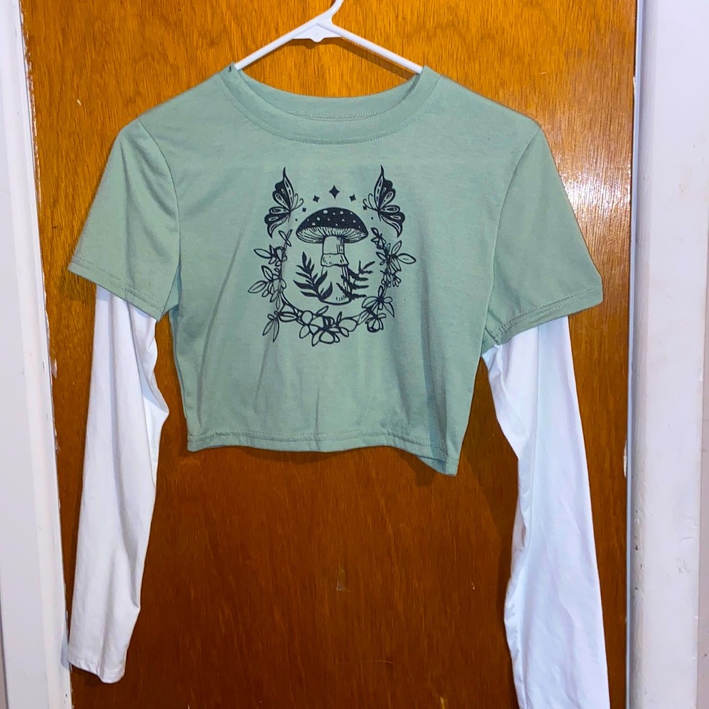 A vibrant green top with white sleeves, adorned with an adorable mushroom logo